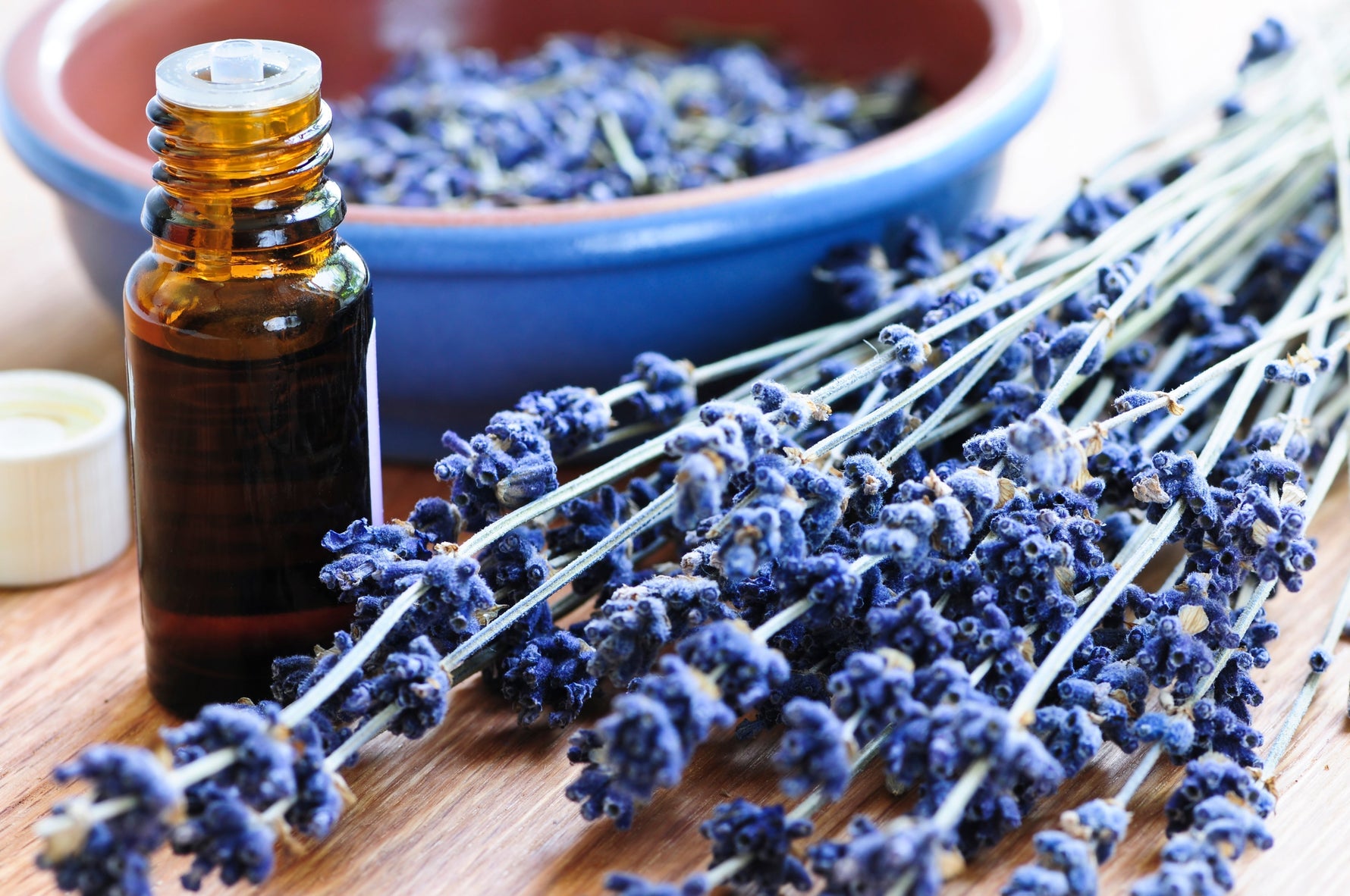 Lavender essential oil next to lavender plant