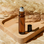 Amber roller bottle on wooden tray with pampas grass