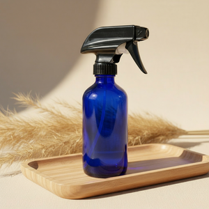 Blue spray bottle on wooden tray with pampas grass