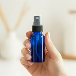 Hand holding spray bottle with transparent cap