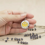 Hand holding yellow lotus necklace