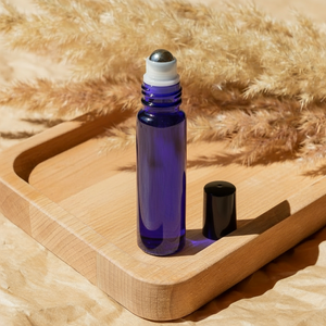 Purple roller bottle with black cap on wooden tray